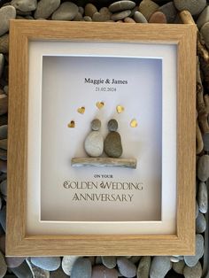 a wedding anniversary gift with two rocks in the shape of a couple sitting on a bench