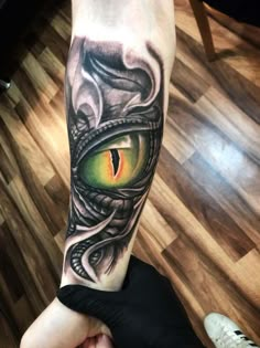 an arm with a dragon eye tattoo on it