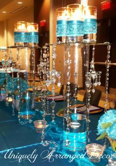 the centerpieces are decorated with blue candles and crystal votives for an elegant touch