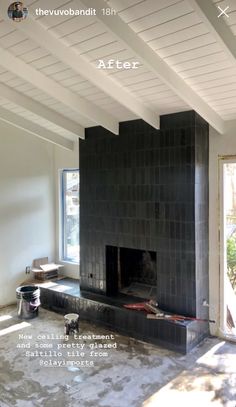 an empty living room with a black fireplace