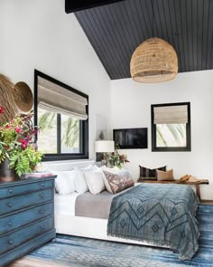 a bedroom with a bed, dresser and large mirror in it's center area