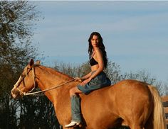 a woman riding on the back of a brown horse