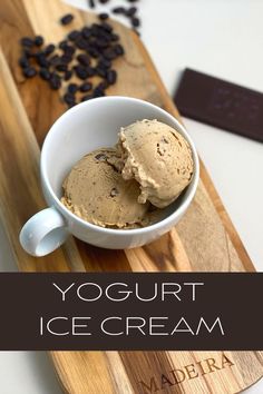 a bowl of ice cream sitting on top of a wooden cutting board next to coffee beans