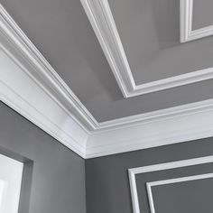 an empty room with gray walls and white trim on the ceiling is shown in this image