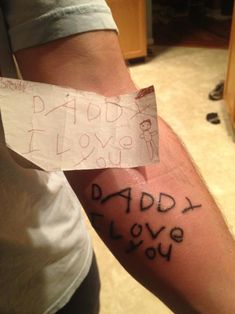 a person holding a piece of paper with the words daddy and i love you written on it