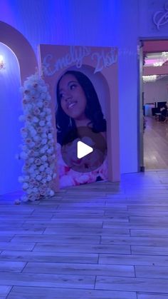 the entrance to an event with blue lighting and flowers on display in front of it