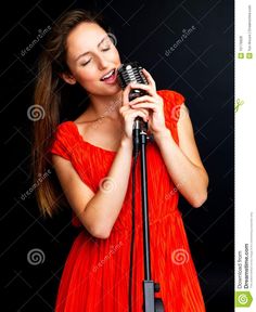 a beautiful woman singing into a microphone