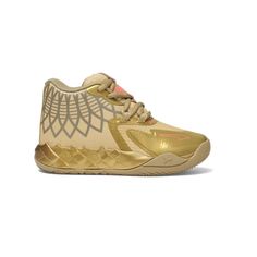 a gold sneaker with an intricate design on the upper and side, in front of a white background