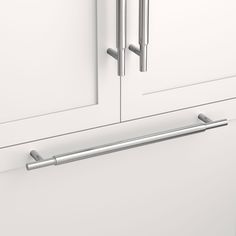 a close up view of the handles on a cabinet door with white cabinets in the background