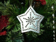 a white ornament hanging from a christmas tree