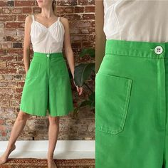 "Vintage 1960s/1970s Kelly green culottes, featuring a high waist, cropped wide leg with a white  button waist and white contrast stitching. They have a patch pocket at each hip and a zipper fly. Expand for more details and measurements.   They are in good/great condition. There is a small run in the fabric near the button hole (See 3rd last photo).   JC Penney Fashions 50% Cotton, 50% Polyester Likely made in USA Tag sie 11 Fits a 27\" Waist Measurements are done with garment laying flat and ar 60s Shorts Outfits, Green Wide-leg Shorts With Pockets, Green Wide Leg Shorts With Pockets, Retro Wide Leg Cotton Shorts, Wide Leg Buttoned Shorts For Spring, Vintage Wide Leg Bottoms For Spring, Retro Wide Leg Spring Shorts, Spring Vintage Wide Leg Bottoms, Vintage Shorts With Button Closure For Summer