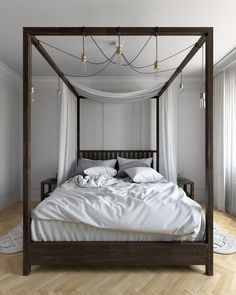 a four poster bed with white sheets and pillows in a room that has hardwood floors