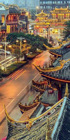 an aerial view of a city with buildings and pagodas in the background at dusk