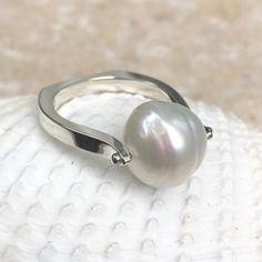 14KT white gold + genuine Paspaley South Sea Pearl Ring. Fashion quality Paspaley pearl. Paspaley Pearls are considered to be the finest South Sea pearls available. Sizing can be customized for an additional charge. Features a modern, European shank band which levels out the ring so there is no slipping and sliding aro Modern White Gold Pearl Ring With Polished Finish, Modern White Gold Sterling Silver Pearl Ring, Modern White Pearl Ring With Polished Finish, Modern Silver Pearl Ring With Polished Finish, Modern Oval Pearl Ring For Anniversary, Modern White Gold Pearl Ring For Anniversary, Modern Pearl Ring For Formal Occasions, Modern White Pearl Ring For Anniversary, Modern White Pearl Ring