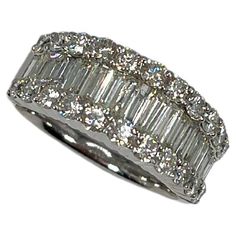 14k white gold 1.15 CTW baguette and .90 CTW round diamond band. The Band has baguettes in the center, and round diamonds going along the top. The Width of the ring is 8.6 mm, has a weight of 6.86, and the size of the ring is a 7. Gia Certified Baguette Cut Diamond Ring, 14k White Gold Baguette Cut Diamond Jewelry, Platinum Diamond Ring With Baguette Cut, Platinum Baguette Cut Diamond Ring, Round Diamond Band, Diamond Band, The Band, Diamond Bands, Diamond White