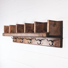 a wooden shelf with several hooks on it