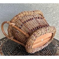 a basket sitting on top of a table next to a tile floor with a wooden handle