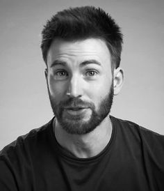 a black and white photo of a man with a beard wearing a t - shirt