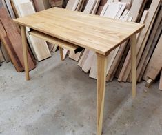 a wooden table sitting in front of stacks of wood