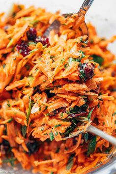 carrot salad with cranberries and herbs in a glass bowl