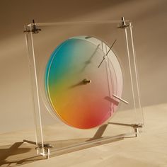 a multicolored clock sitting on top of a wooden table