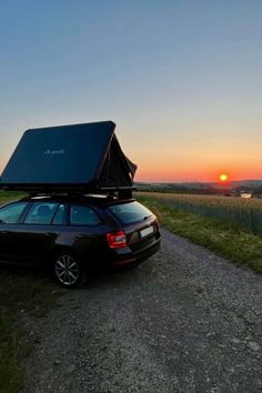 a car parked on the side of a road with a roof tent attached to it