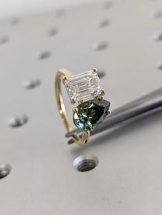 an engagement ring with a green and white diamond