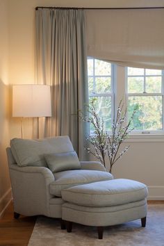 a chair and ottoman in front of a window