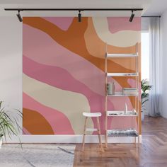 an orange, pink and white abstract painting on a wall in a room with wooden floors