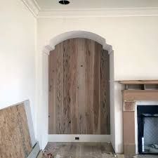 an unfinished room with wood paneling and a fireplace