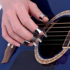 a person is playing an acoustic guitar with their fingers and thumbnails on it