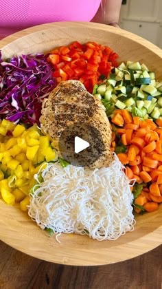 a wooden bowl filled with different types of veggies