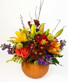 a vase filled with lots of colorful flowers