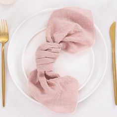 a white plate topped with a pink napkin and fork