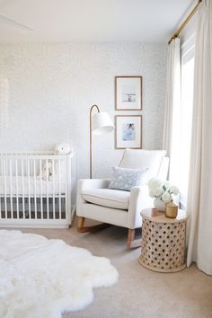 a baby's room with a white crib, rocking chair and rug on the floor