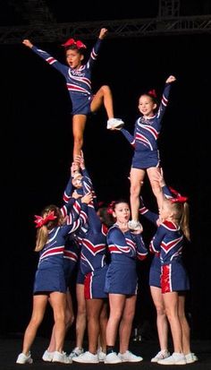 a group of cheerleaders doing stunts on stage