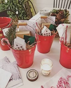 red buckets filled with christmas gifts on top of a table