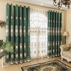 the living room is decorated in green and white colors, with an ornate chandelier