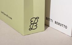 two boxes sitting side by side on top of a white surface with black lettering that reads beti bertuto