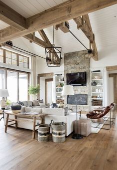 a living room filled with furniture and a flat screen tv mounted on the wall above a fireplace