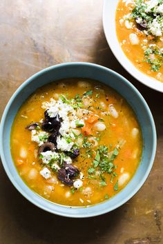 two bowls filled with soup on top of a table