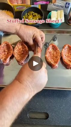 a person is cooking some meat on a grill with other food items in the background