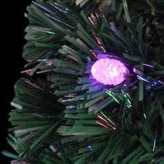 a close up of a christmas tree with purple lights on it's ornament