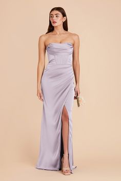 a woman wearing a strapless dress with high slit