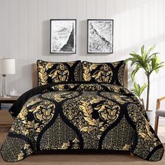 a black and gold comforter set with two pictures on the wall in front of it