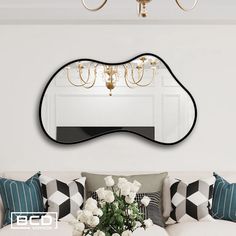 a living room with a couch, chandelier and mirror on the wall above it