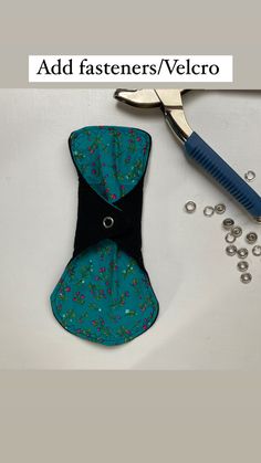 a pair of scissors sitting on top of a piece of fabric next to some beads