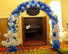 an archway decorated with blue and white balloons