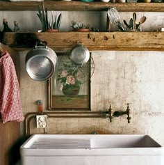 a kitchen sink with pots and pans hanging on the wall