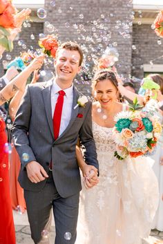 a bride and groom are walking through bubbles